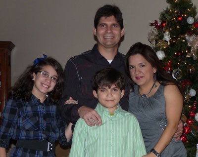 Family portrait of four - mother, father and two young kids 